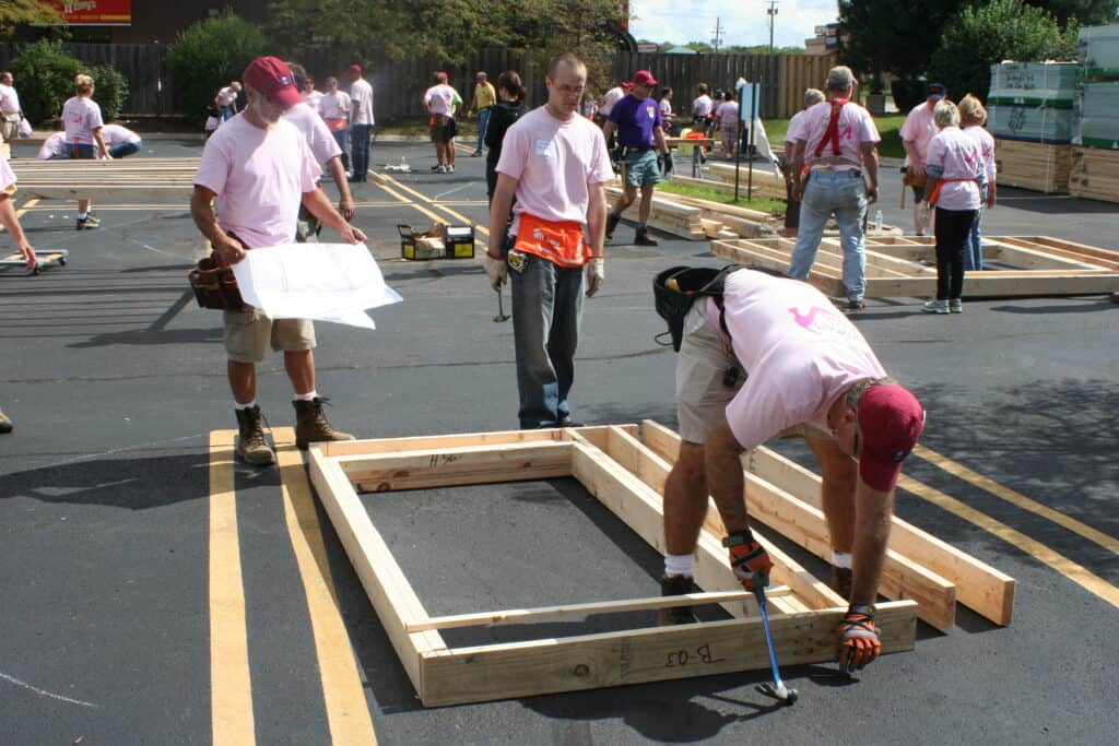 People working on building a wood frame